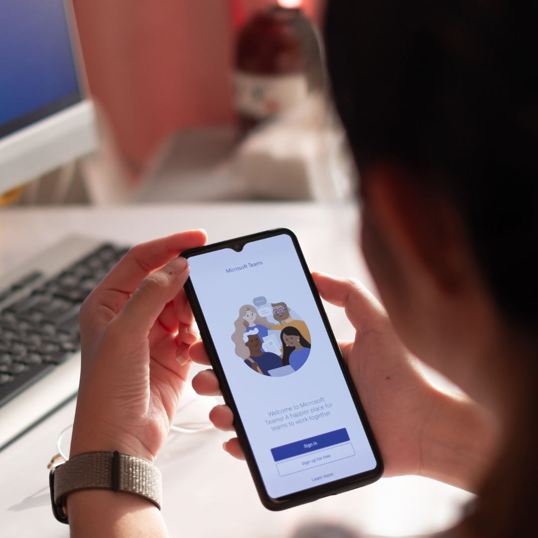 User opening the Microsoft Teams app on a mobile phone during a Microsoft 365 licensing review.