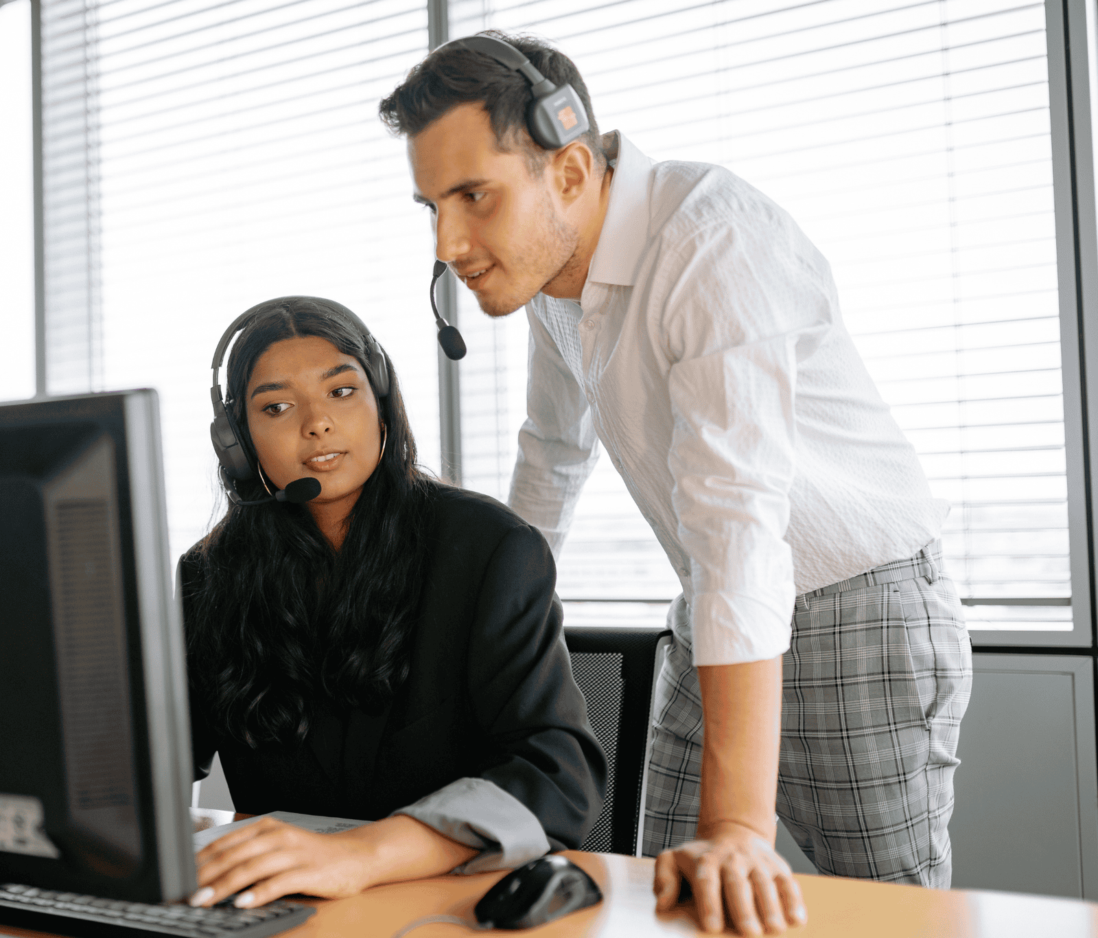 Two people looking at a computer screen working together