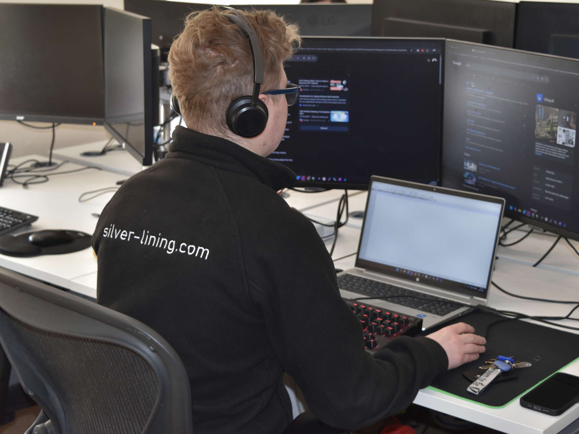 IT support specialist working at a desk with multiple monitors, providing managed IT services and technical support for UK businesses.